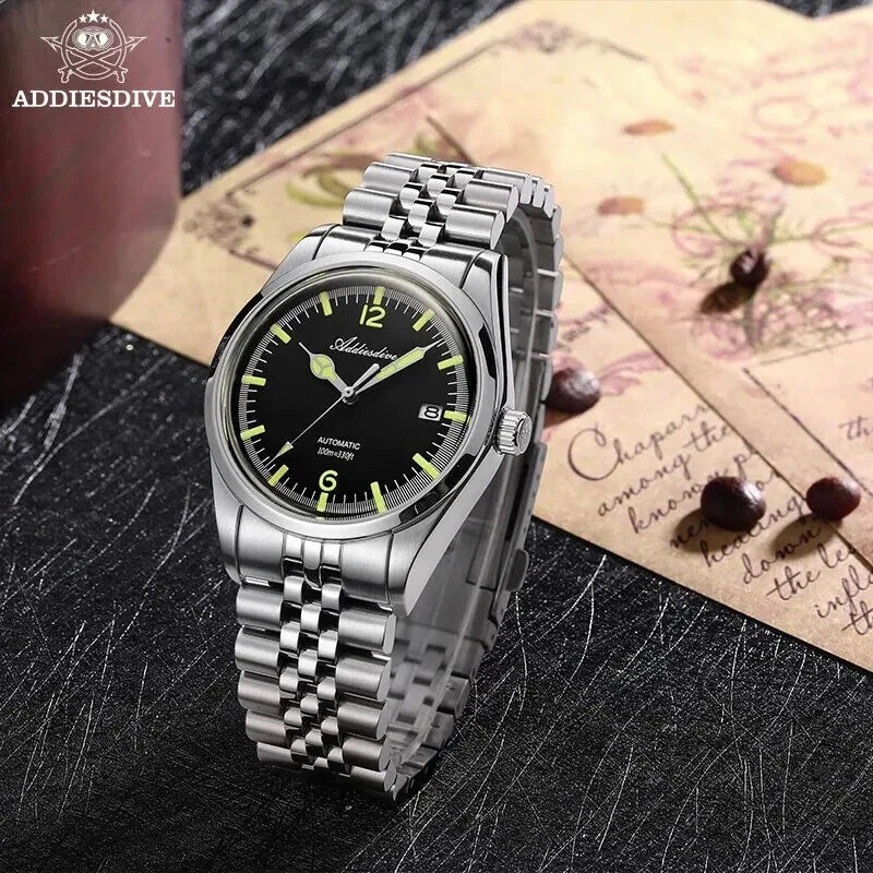 Silver wristwatch with black dial on a textured surface, featuring the ADDIESDIVE brand.
