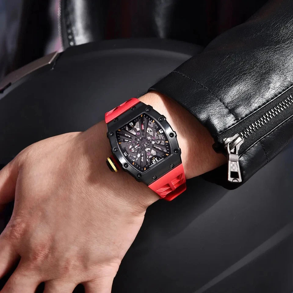 Red and black watch on a person's wrist with a dark background
