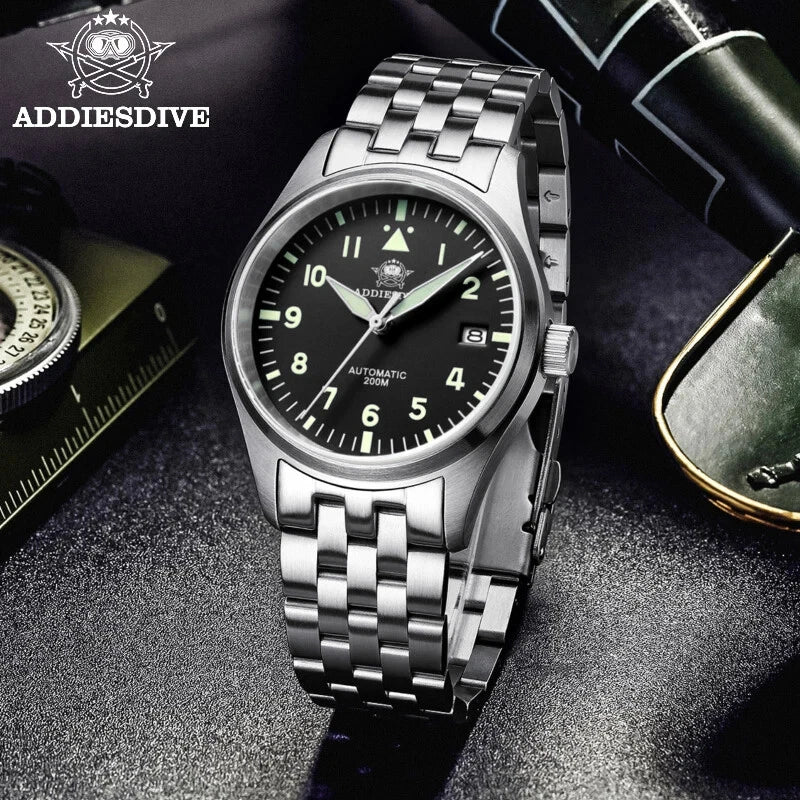 Silver wristwatch with black dial on a dark textured surface, featuring ADDIESDIVE branding.
