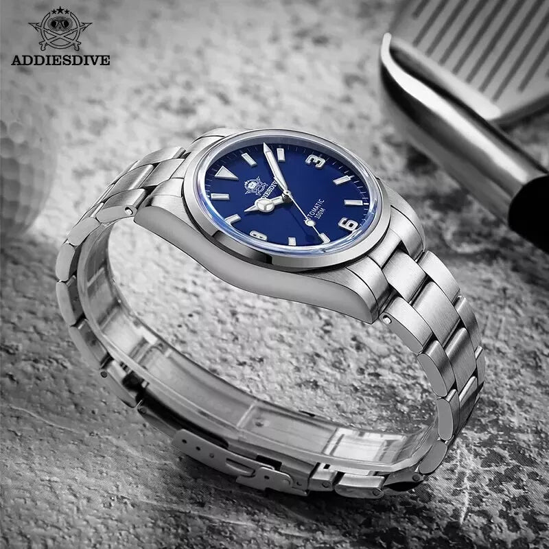 Silver watch with blue dial on a textured surface, featuring the ADDIESDIVE brand.