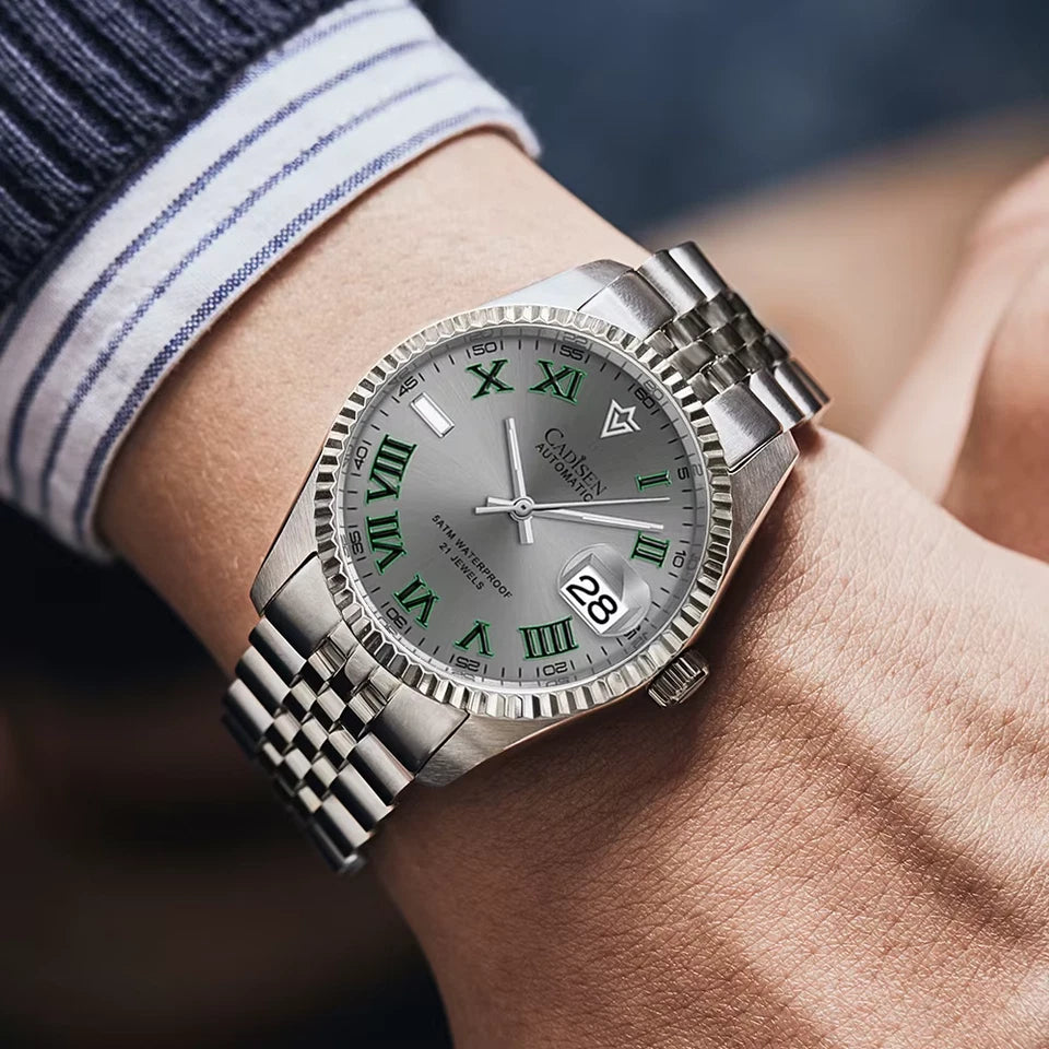 Silver watch with green Roman numerals on a wrist, brand 'Cameley' visible