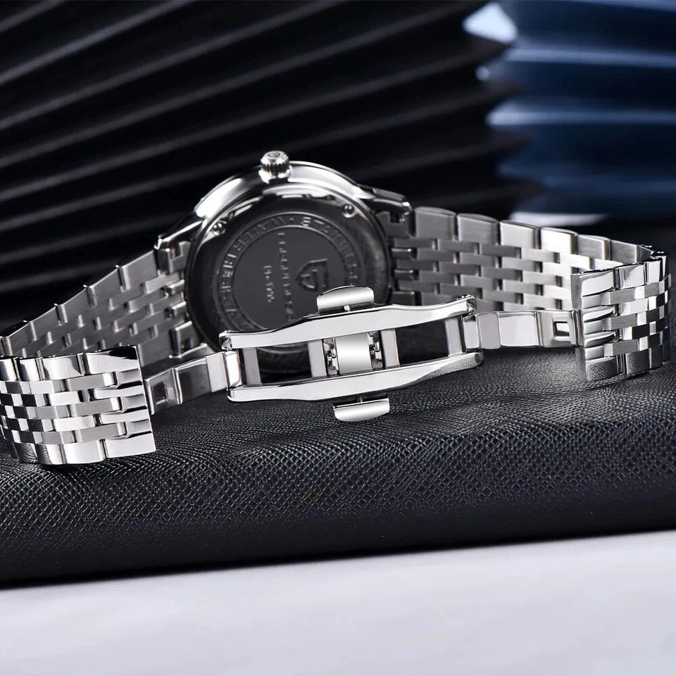 Silver watch with a detailed face on a black textured surface