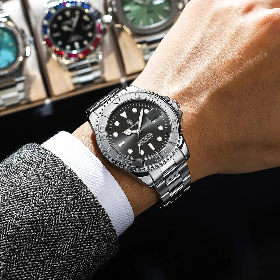 Close-up of a person wearing a silver watch with a dark face, with other watches in the background.