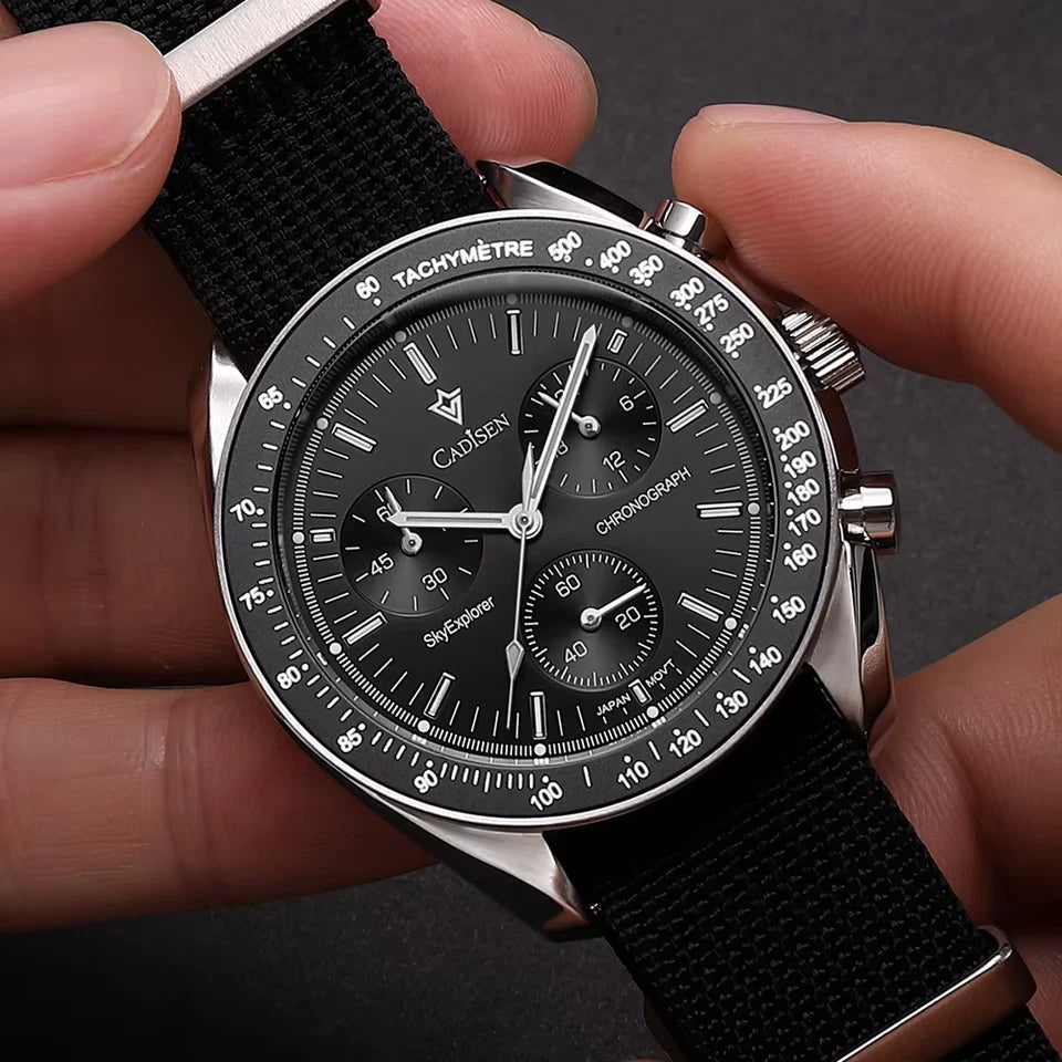 Close-up of a person holding a black wristwatch with detailed face