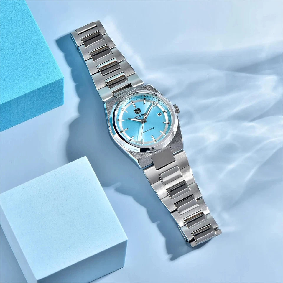 Silver watch with a blue face on a light blue background