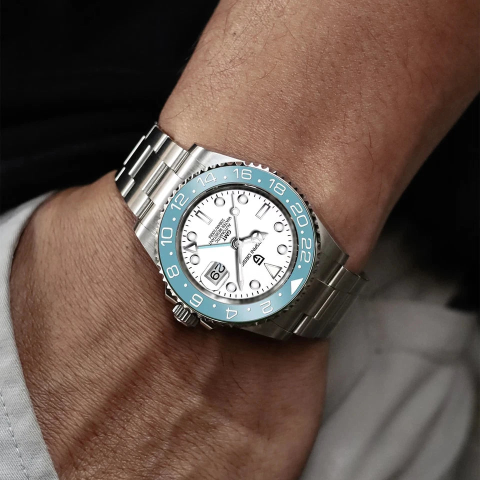 Close-up of a wrist wearing a silver watch with a white face and blue bezel.