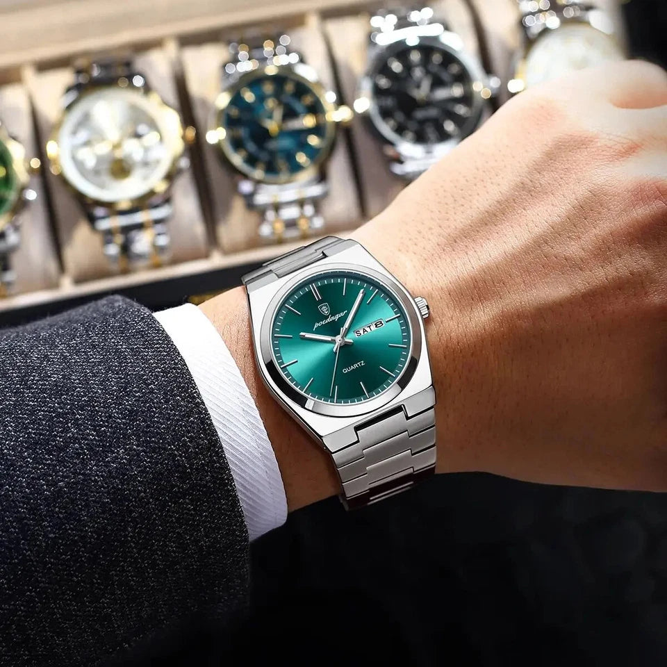 Person wearing a silver watch with a green face, with a display of similar watches in the background.