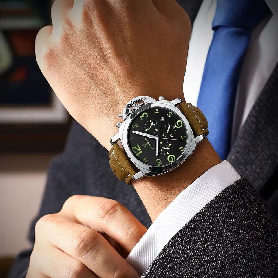 Close-up of a wrist wearing a watch with a brown leather strap, dressed in formal attire.
