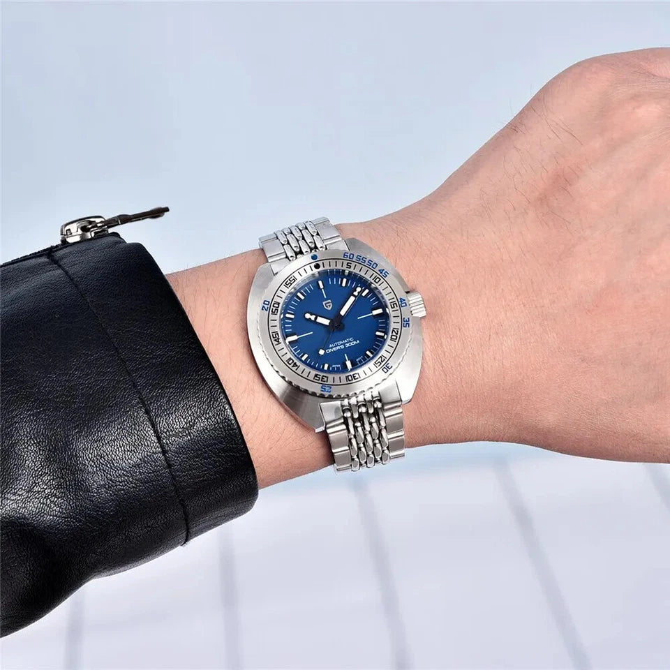 Silver watch with a blue face on a wrist against a light blue background
