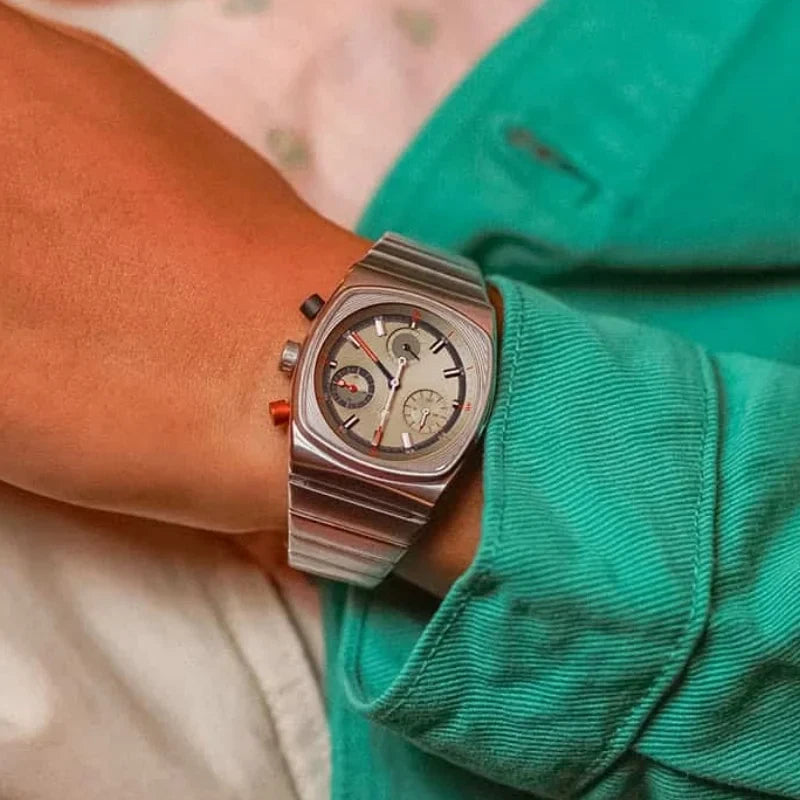 Silver watch on a wrist with a green sleeve