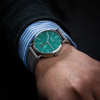 Seestern S382 turquoise dial dress watch on grey suede strap on the wrist with striped cuff, lifestyle