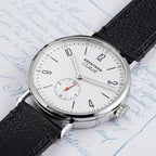 Seestern S382 silver-white dial dress watch on black leather strap on script paper, flat lay