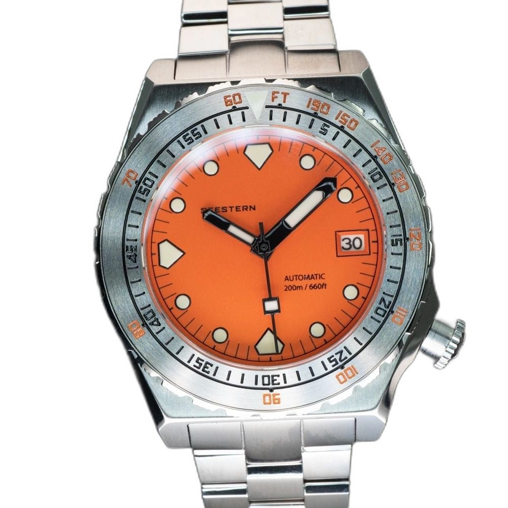 Seestern S407 orange ceramic diver on steel bracelet resting on brown leather, angled view