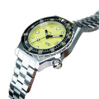 Seestern S407 yellow ceramic diver on steel bracelet resting on brown leather, angled view