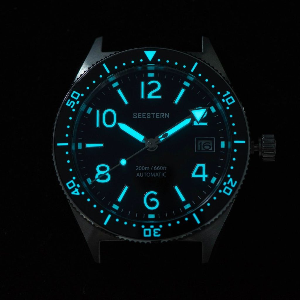 Seestern S434-2 skin diver dial and bezel glowing blue-green lume in the dark, close-up
