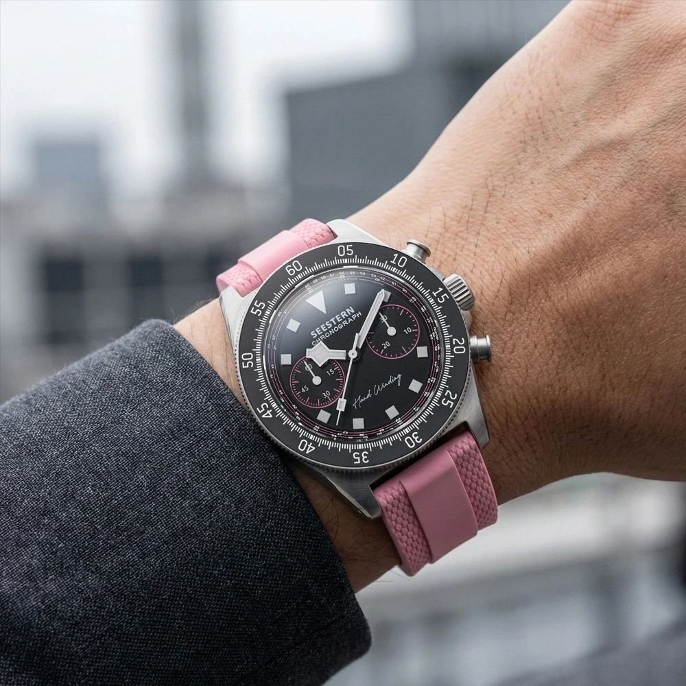 Seestern S443 chronograph on pink rubber strap worn on wrist, black-and-pink dial, city backdrop