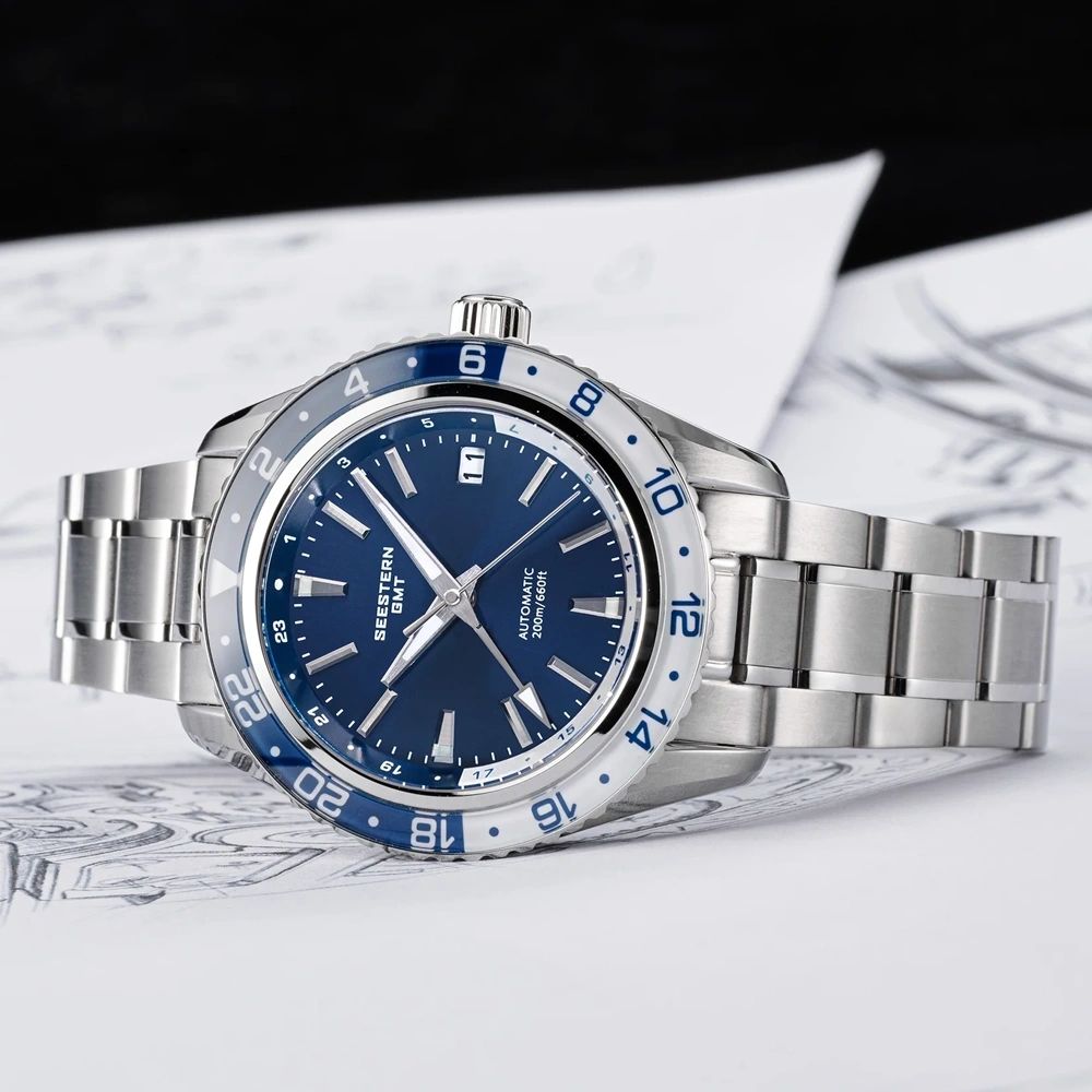 Seestern S456 navy-dial GMT on steel bracelet, flat-lay on designer sketch backdrop