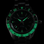 Seestern S456 GMT dial and bezel glowing blue-green lume in the dark with red GMT hand, close-up