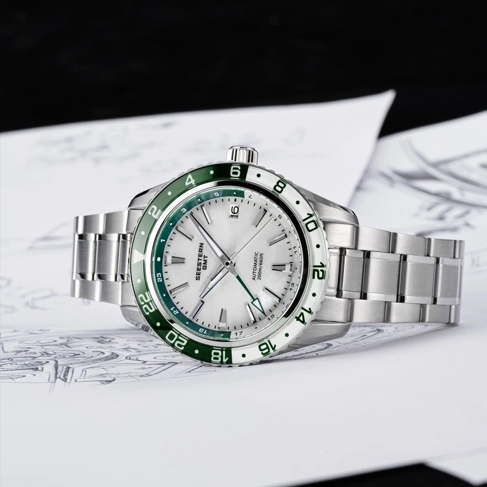 Seestern S456 white MOP-dial GMT with green bezel, flat-lay on designer sketch backdrop