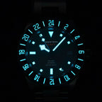 Seestern S462 titanium GMT black dial and bezel glowing blue-green lume in the dark, front close-up