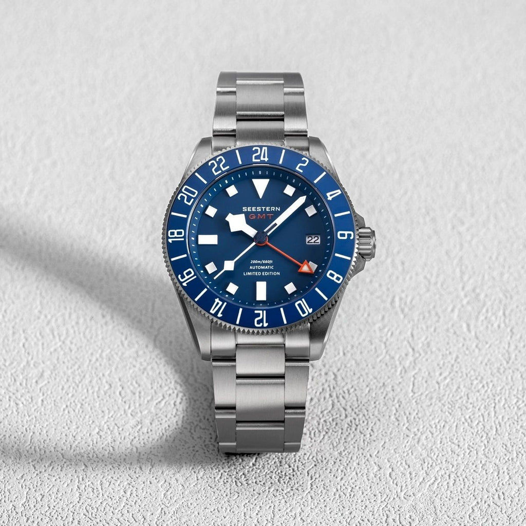 Seestern S462 titanium GMT, blue dial, front flat-lay on white textured surface, steel bracelet