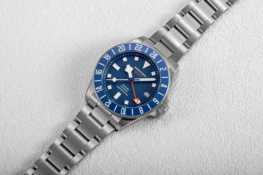 Seestern S462 titanium GMT, blue dial, flat-lay on white textured surface, steel bracelet