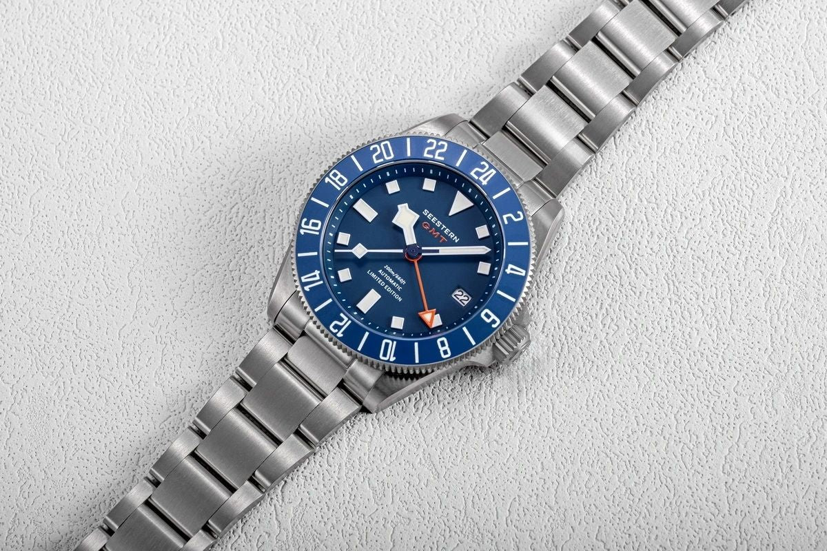 Seestern S462 titanium GMT, blue dial, flat-lay on white textured surface, steel bracelet