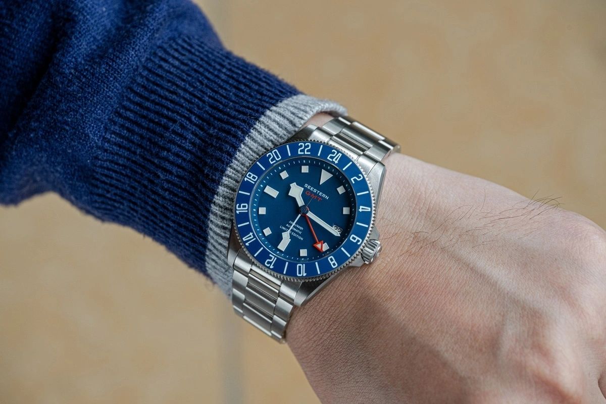 Seestern S462 titanium GMT blue-dial diver worn on wrist over a navy sweater, steel bracelet