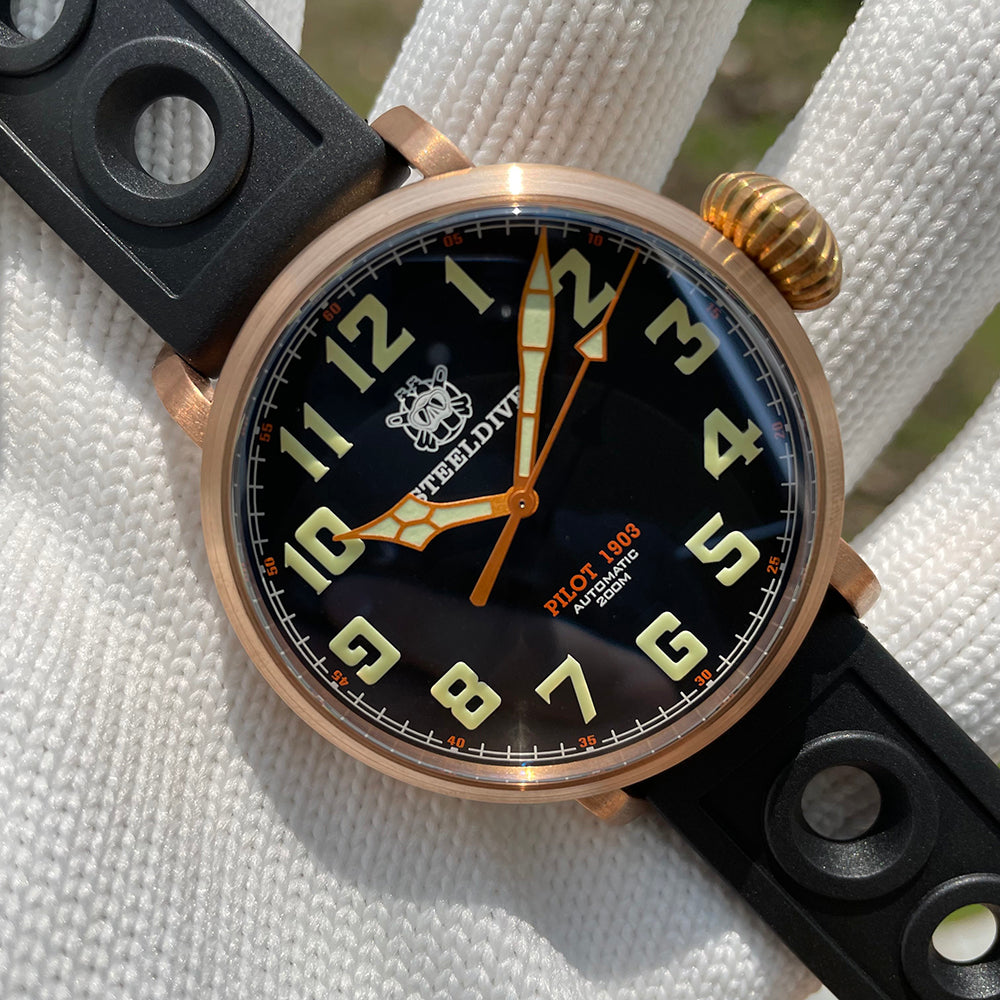 Steeldive SD1903S bronze pilot watch top-down view with black dial, C3 green numerals and orange cathedral hands