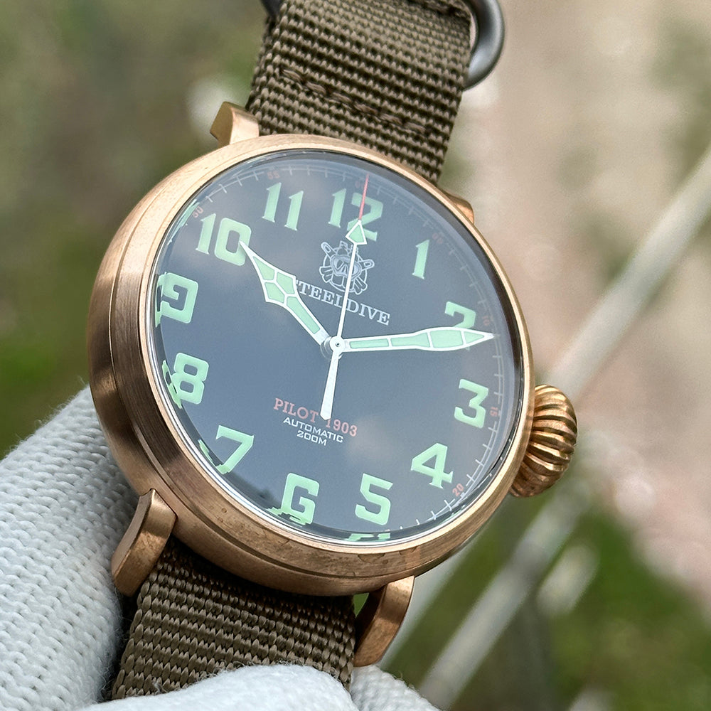 Steeldive SD1903S pilot watch black dial with green numerals and red seconds, three-quarter angle on olive NATO