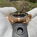 Steeldive SD1903S bronze pilot watch low angle view with black dial, onion crown and perforated rubber strap