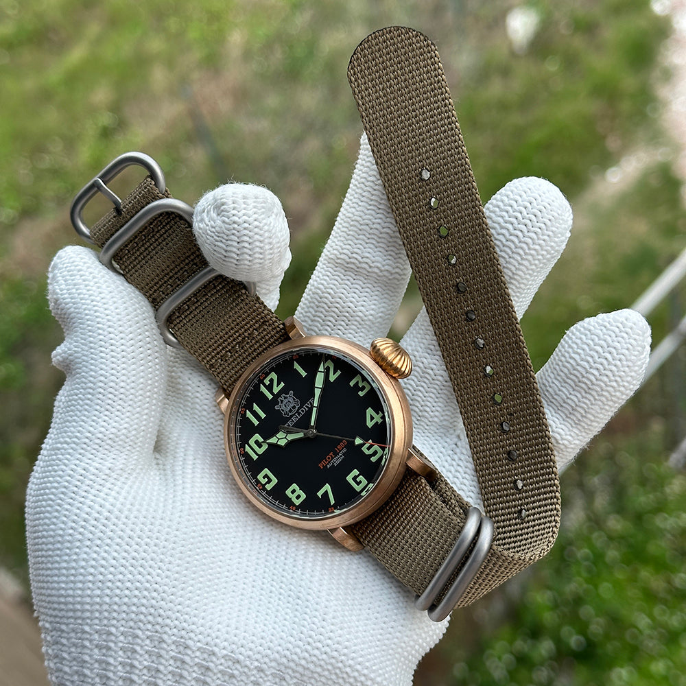Steeldive SD1903S bronze pilot watch with olive NATO strap fully extended in gloved hand, lifestyle display