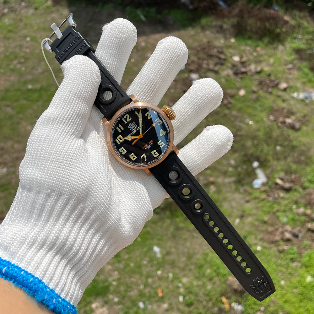 Steeldive SD1903S bronze pilot watch held in gloved hand showing 46.5mm case scale and rubber strap length