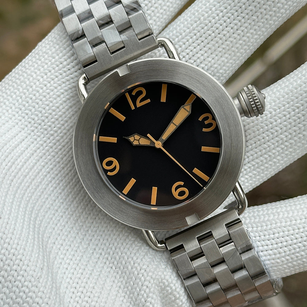 Steeldive SD1912 dial macro showing black face, faux-patina Arabic numerals and aged syringe hands at 47mm