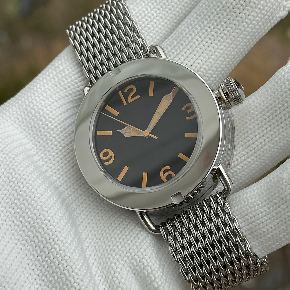 Steeldive SD1912 black dial macro with orange Arabic numerals, gold spear hands and shark mesh bracelet