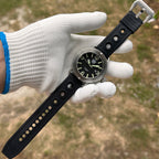 Steeldive SD1912 V2 brushed dive watch with black rubber strap held in white gloved hand outdoors