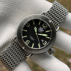 Steeldive SD1912 V2 brushed 3000M dive watch on steel shark mesh bracelet resting on white cloth