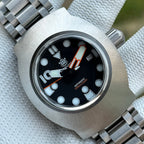 Steeldive SD1920 1000m dive watch front view, black dial with dot indices, 6-9-12 numerals and tank bracelet