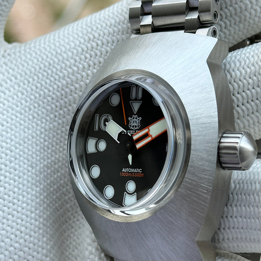 Steeldive SD1920 sapphire glass installed on dive watch with black dial and orange accents, macro view
