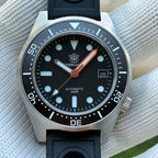 Steeldive SD1929 dial macro showing black dial, applied indices, orange seconds hand and date window