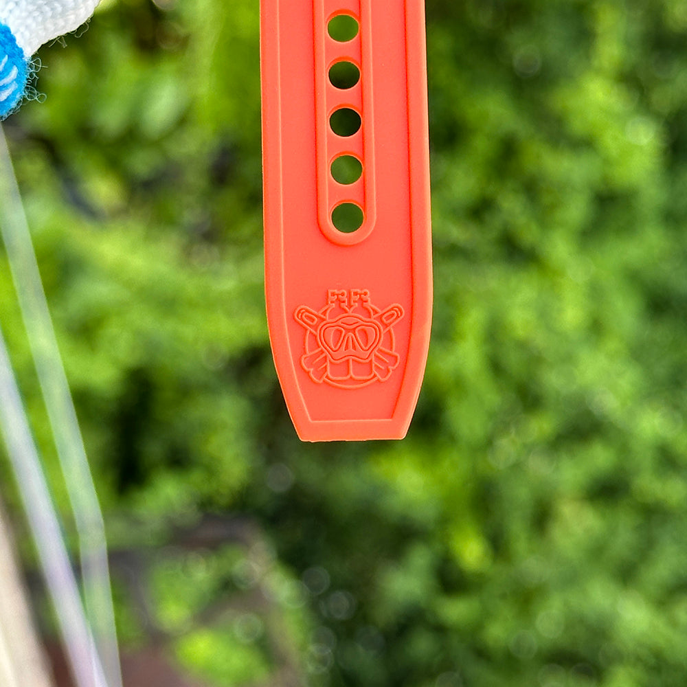 Steeldive SD1929 orange rubber dive strap tail showing diver-helmet emblem and ventilation holes