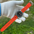 Steeldive SD1929 dive watch resting on gloved hand with full orange rubber strap and steel buckle displayed