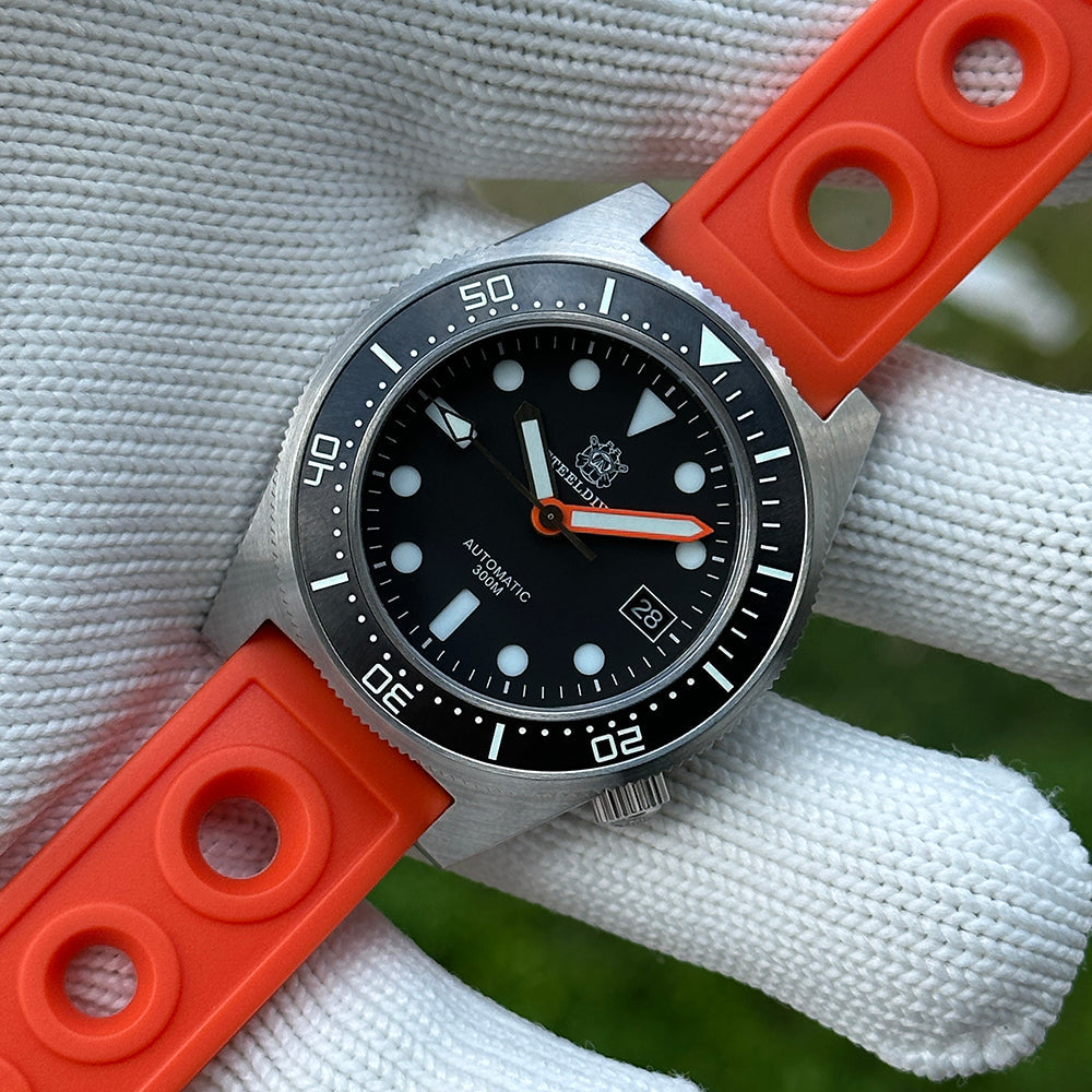 Steeldive SD1929 black dial dive watch held on gloved hand with orange rubber strap, front angle