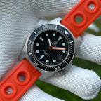 Steeldive SD1929 black dial dive watch held on gloved hand with orange rubber strap, front angle