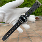 Steeldive SD1930 pilot watch on perforated black rubber strap laid flat, signed buckle and engraved tail