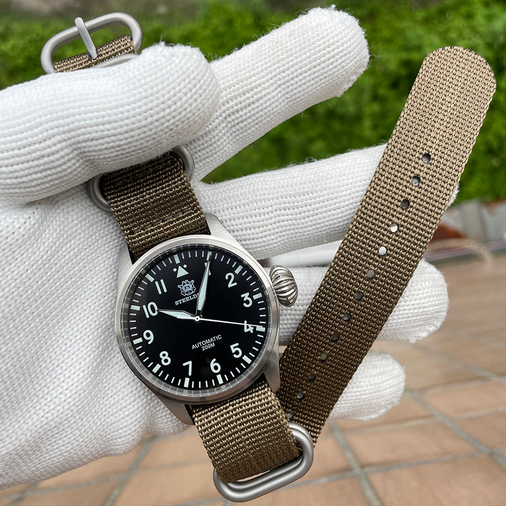 Steeldive SD1930 pilot watch laid flat on khaki zulu nylon strap with brushed steel hardware