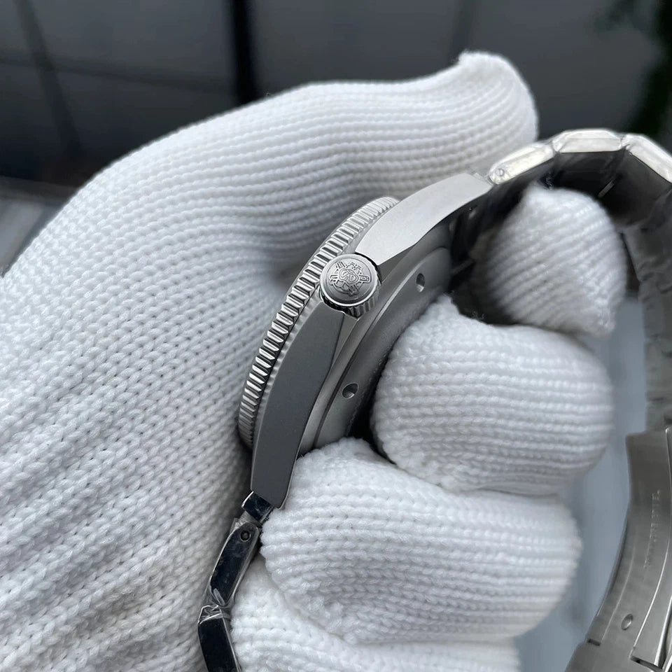 Side view of Steeldive SD1944 watch showing stainless steel case, crown and bezel edges, held by a white gloved hand, with blurred background.