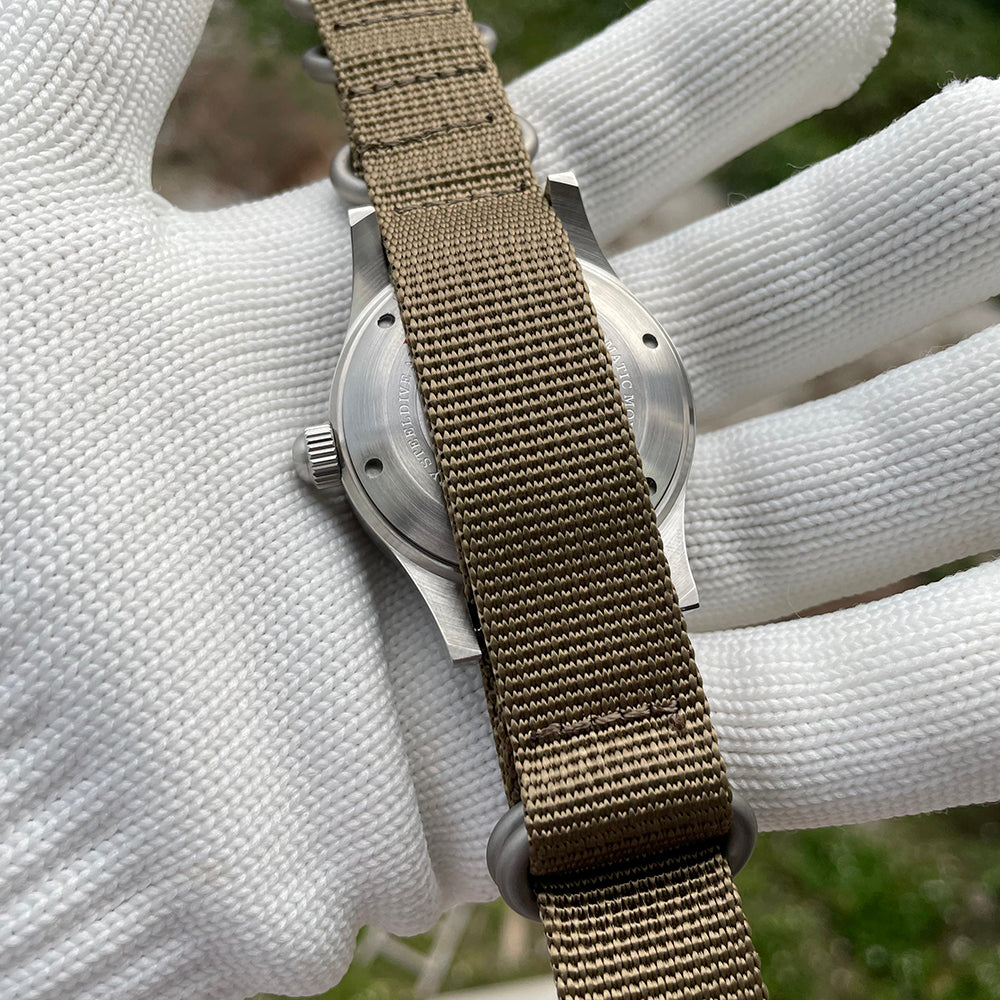 Steeldive SD1952 caseback view through khaki NATO strap pass-through, brushed stainless steel