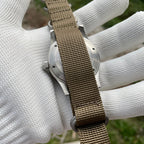 Steeldive SD1952 caseback view through khaki NATO strap pass-through, brushed stainless steel