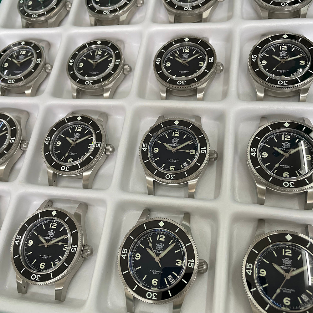 Steeldive SD1952 fifty fathoms black dial dive watches lined up in factory tray, comparison overview